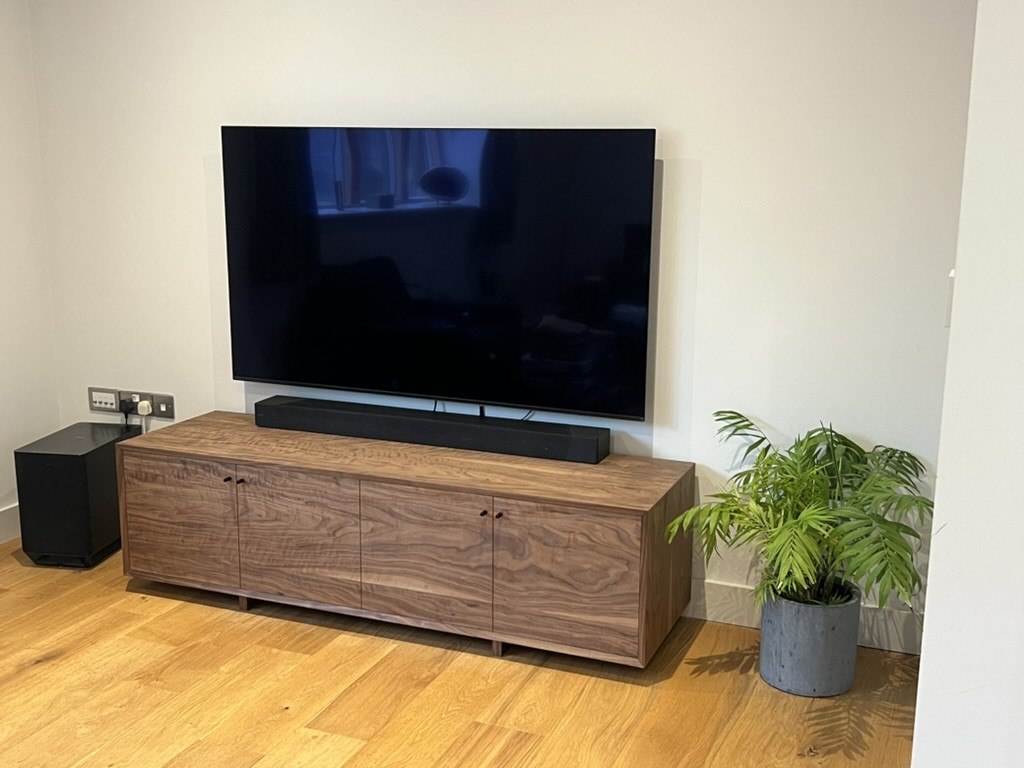 Bespoke walnut media unit installed in a living room, handmade by Mark Eden Design