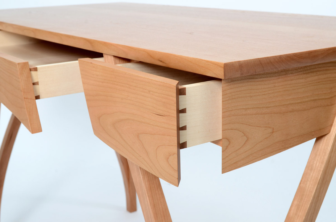 Close-up detail of hand-cut dovetail joinery on cherry desk drawers, crafted by Mark Eden Design