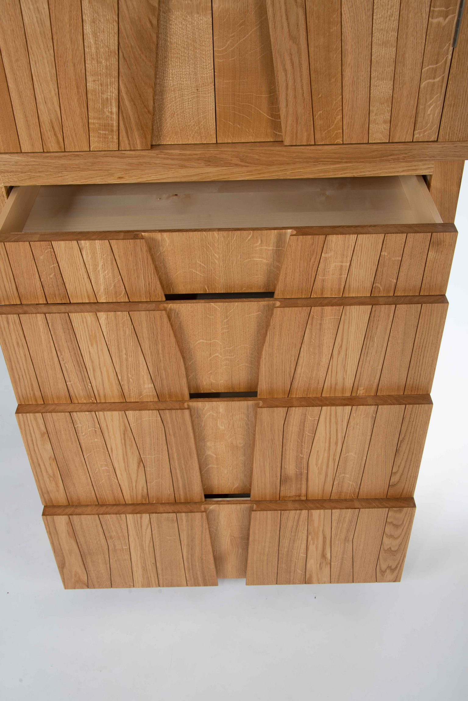 Detail of bespoke oak cabinet with open drawers revealing hand-cut dovetail joints